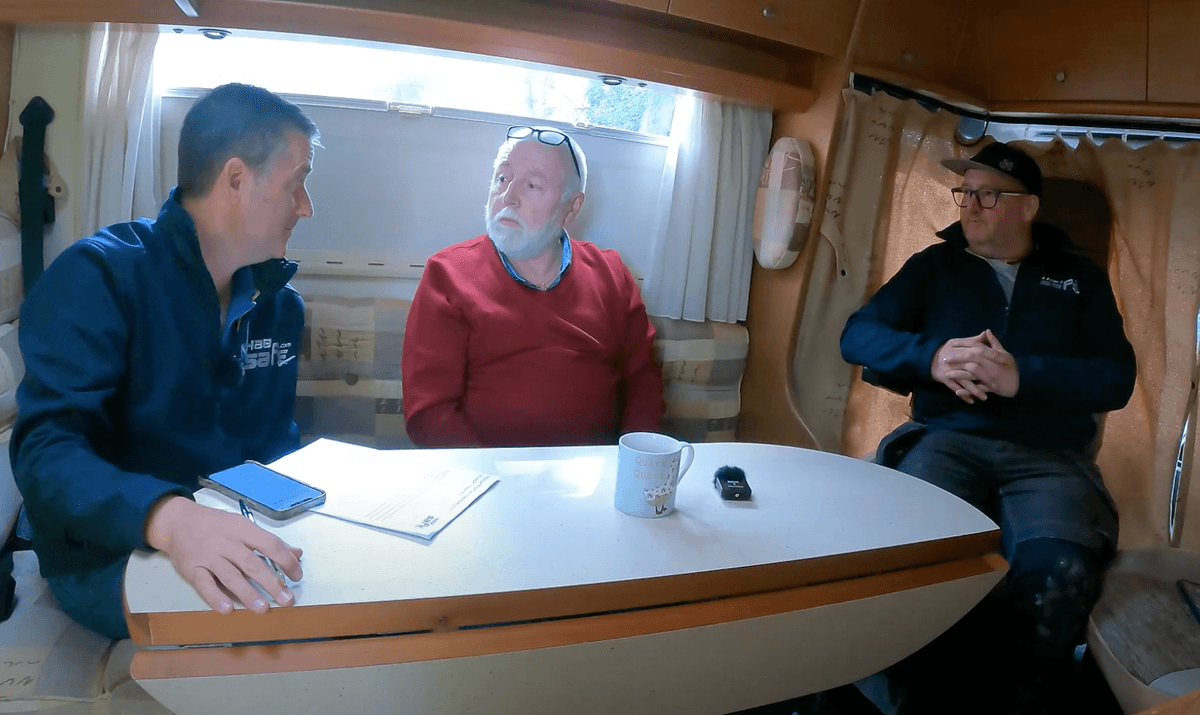 Sell My Motorhome Yorkshire team and owner in RV, discussing sale, with earnest expressions