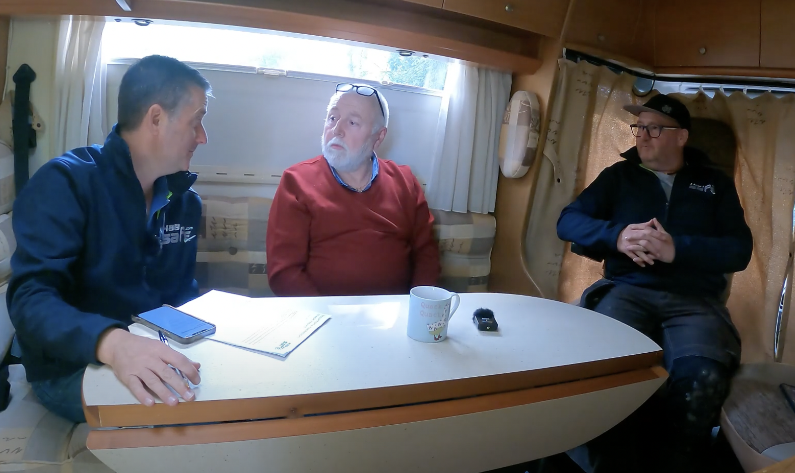 Sell My Motorhome Yorkshire team and owner in RV, discussing sale, with earnest expressions